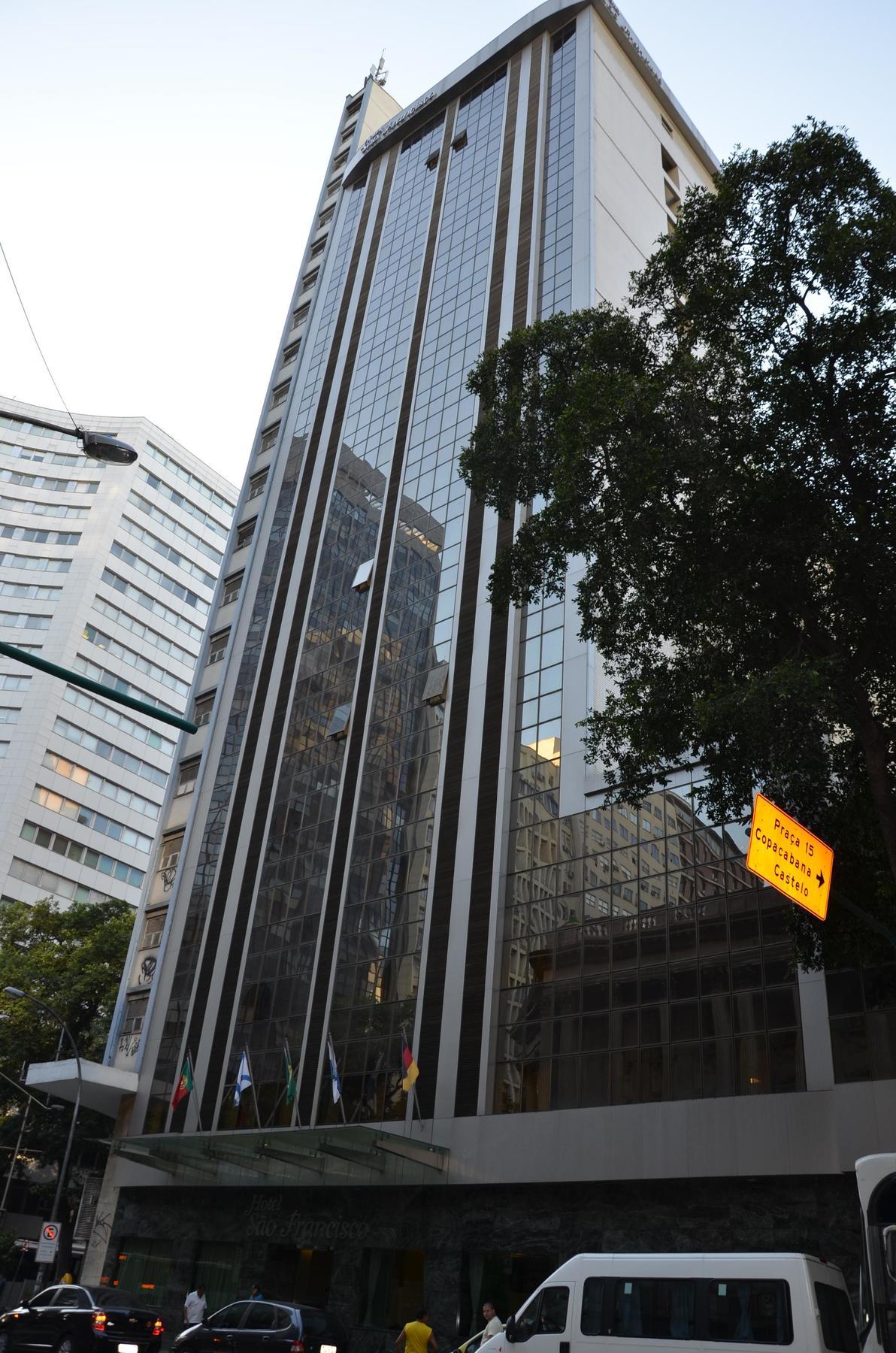 阿特兰蒂科托尔酒店 里约热内卢 外观 照片 The photo shows a city street with tall buildings. In the foreground, there is a modern glass skyscraper featuring reflective surfaces and vertical lines. Next to it, there's another building with a different architectural style, also made of glass. 